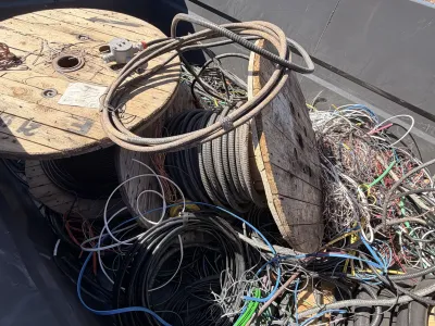 Loose pile of scrap wire staged on wooden spools at a pickup lot